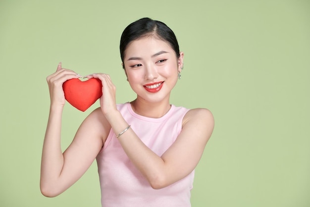 Bella dama sosteniendo pequeñas postales de corazón de papel haciendo invitación de cita sorpresa de novio