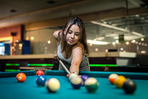 Bella dama toma un tiro fácil para ganar en el juego de billar