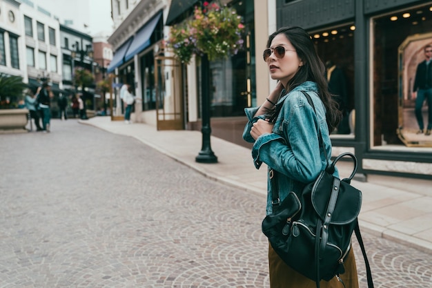 la bella dama vio una tienda de ropa de moda que estaba teniendo una gran venta y se detuvo en la calle mientras caminaba