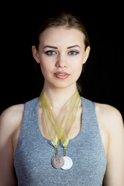 Una bella deportista en un traje gris con una medalla alrededor del cuello.