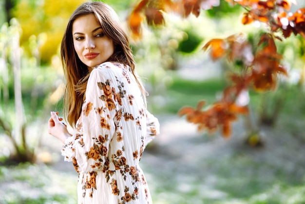 Bella joven cerca del árbol de primavera en flor chica atractiva disfrutando de su tiempo afuera en el parque