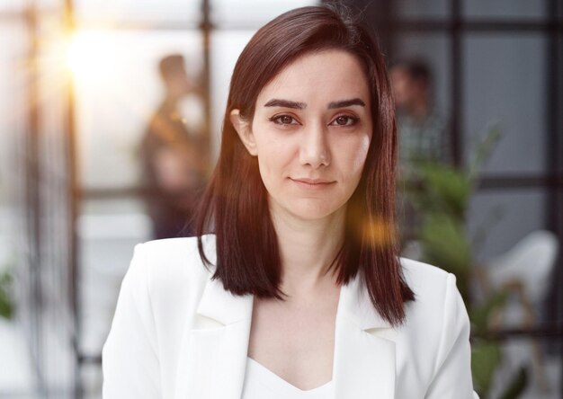 Bella joven con chaqueta blanca sonriendo a la cámara