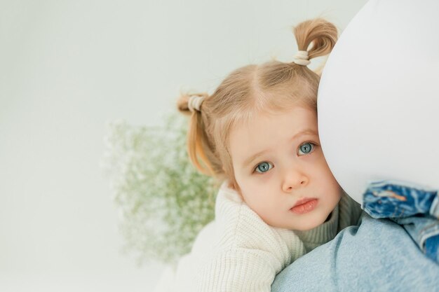 Bella joven embarazada con un ramo de flores de primavera con su pequeña hija de 3 años