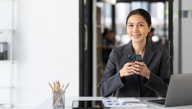 Bella joven mujer de negocios usando el teléfono en la oficina