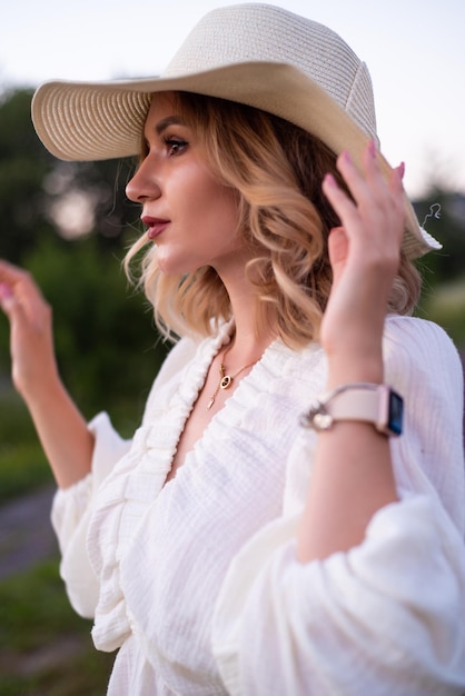 bella joven con vestido blanco y sombrero en el campo de lavanda