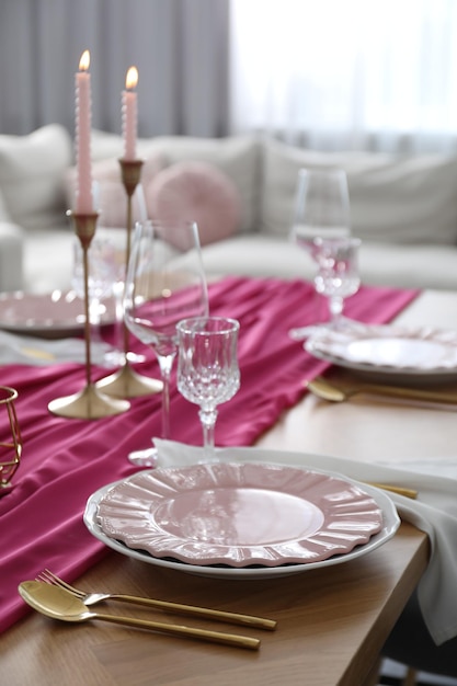 Bella mesa con velas encendidas y acento rosado en el comedor