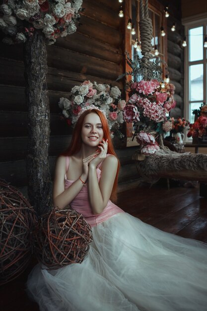 Bella modelo está posando con flores y maquillaje creativo