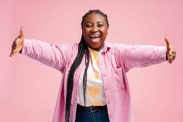 Bella mujer afroamericana sonriente y emocionada con cuerpo positivo con abrazos mirando a la cámara