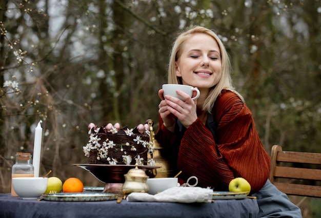 Bella mujer bebiendo un té en un jardín.