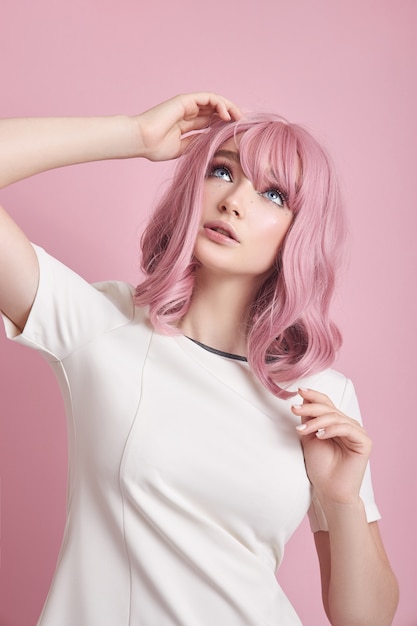 Bella mujer con cabello rosado y un vestido blanco