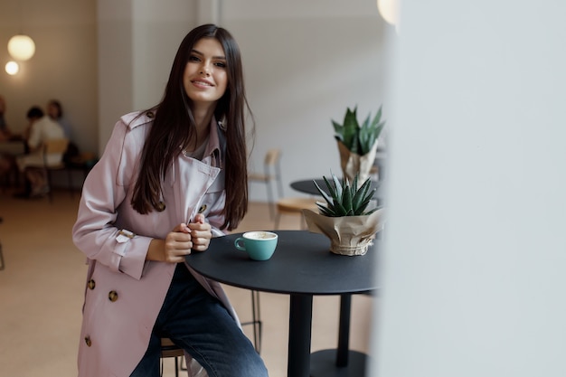 Bella mujer en una cafetería con una taza de café