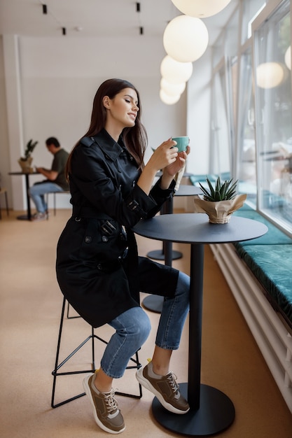 Bella mujer en una cafetería con una taza de café