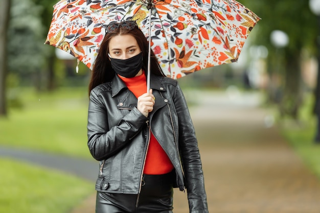 Bella mujer caminando por la calle con máscara protectora