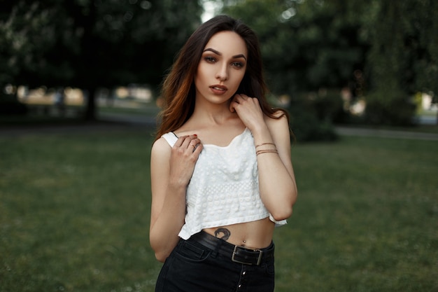 Bella mujer con una camiseta blanca posando en el parque