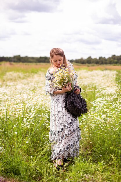 Bella mujer en el campo con flores