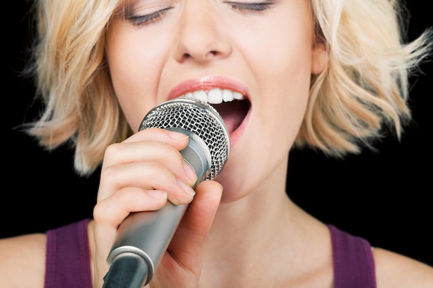 Bella mujer cantando en micrófono