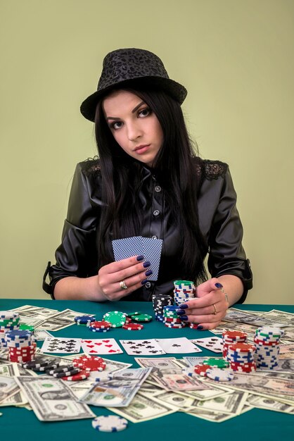 Bella mujer en casino con cartas y fichas