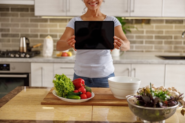 Foto bella mujer está cocinando deliciosos platos en la cocina de su casa