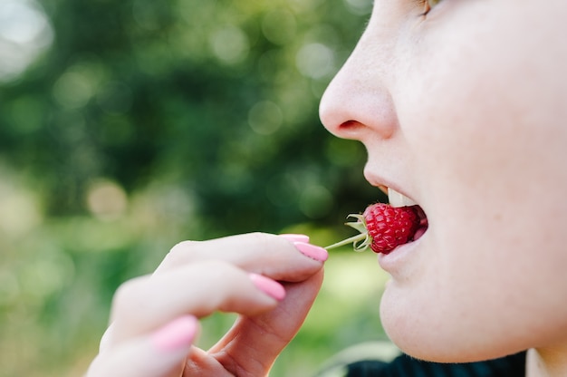 Foto bella mujer comiendo frambuesa