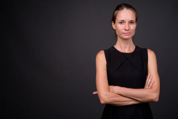 Bella mujer contra la pared gris