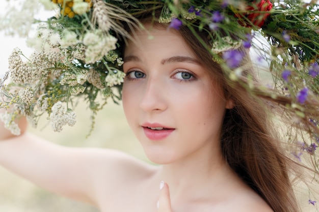 Bella mujer con corona de flores en la cabeza.