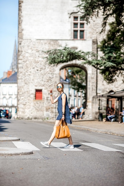 Bella mujer cruzando la calle en el casco antiguo de la ciudad de Nantes en Francia