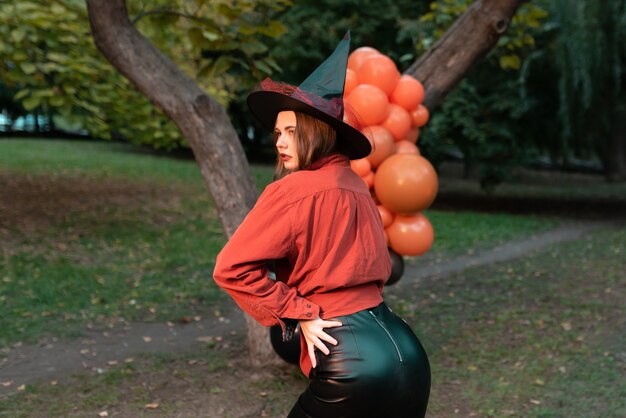 Bella mujer en un disfraz de bruja con globos para Halloween. Concepto de decoración de Halloween