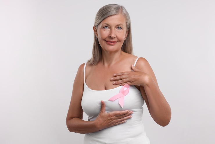 Foto bella mujer de edad avanzada con cinta rosa sobre fondo blanco concienciación sobre el cáncer de mama