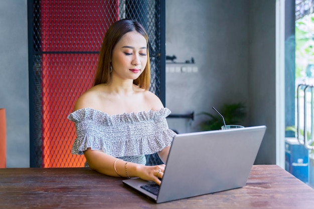 Bella mujer escribiendo en la computadora portátil en el restaurante