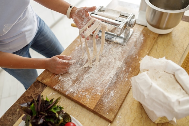 Bella mujer está cocinando deliciosos platos en la cocina de su casa