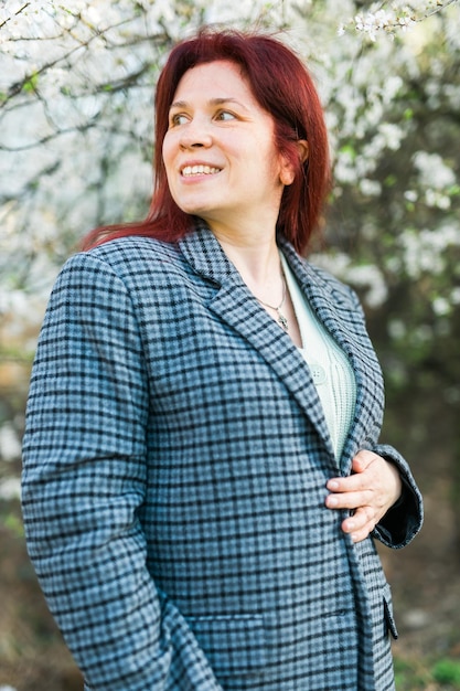 Foto bella mujer feliz del milenio disfrutando del olor en un jardín de primavera en flor tiempo de árbol en flor