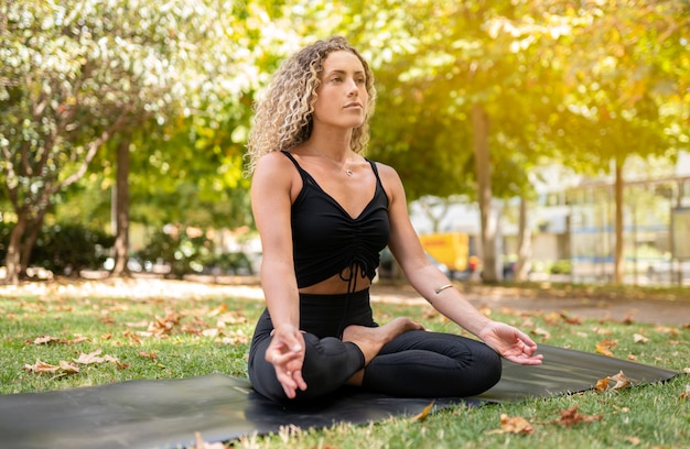 Bella mujer haciendo yoga en la calle