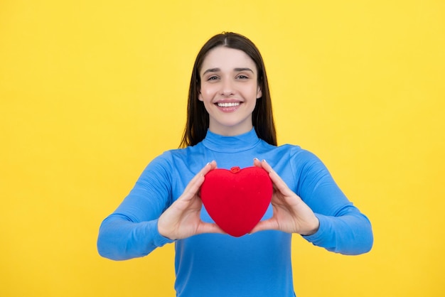 Bella mujer increíble acurrucar tarjeta de papel forma de corazón soñador aislado en fondo amarillo concepto de amor