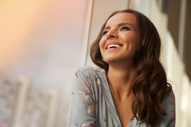 Bella mujer joven feliz sonriendo mira lejos en el fondo de la ciudad ideal sonrisa dentada