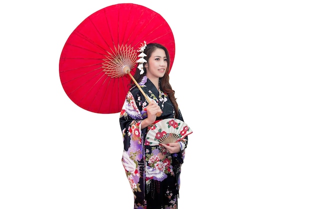 Bella mujer en kimono sosteniendo un paraguas rojo contra un fondo blanco