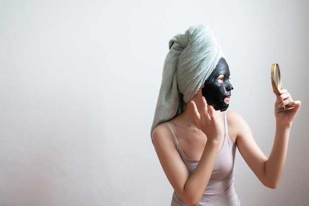 Foto bella mujer con máscara facial negra, concepto de estilo de vida