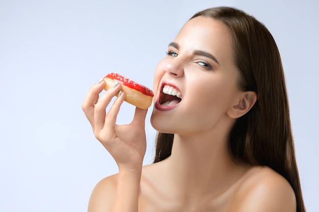 Bella mujer mordiendo una rosquilla