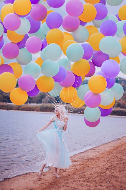 Foto bella mujer con muchos globos