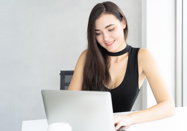 Bella mujer de negocios usando una computadora portátil en el escritorio de la oficina