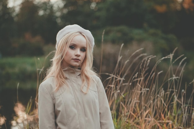 Bella mujer de otoño sola en el fondo de la naturaleza de otoño