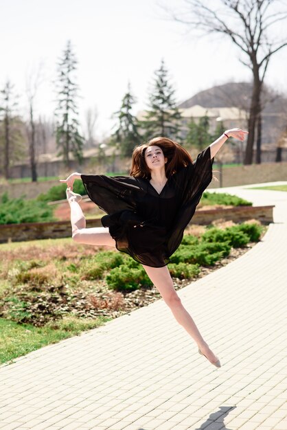 Bella mujer participa en la coreografía en el parque