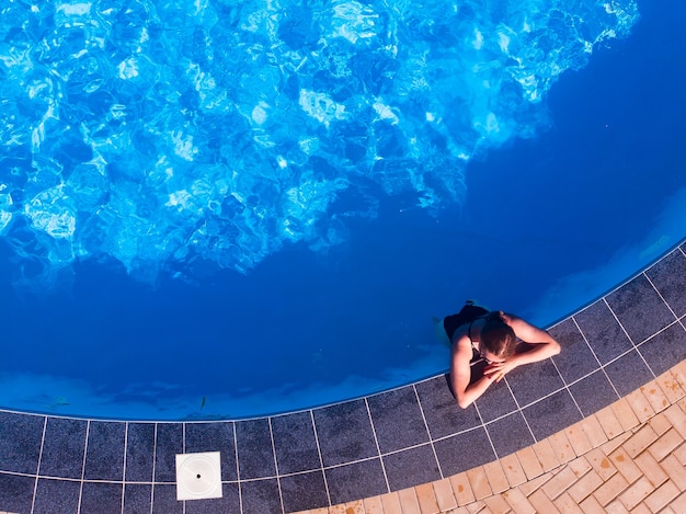 Bella mujer en la piscina del hotel