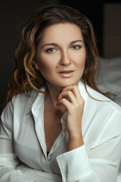 Bella mujer posando con una camisa blanca