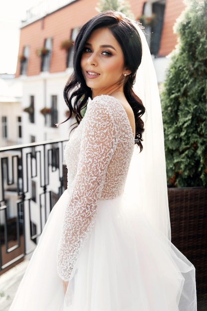 La bella mujer posando en un vestido de novia