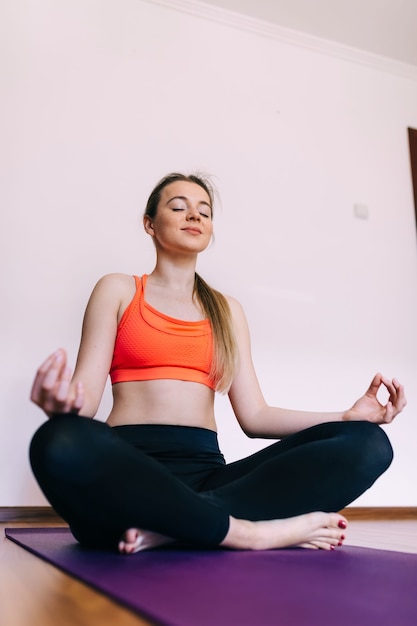 Bella mujer practica yoga en casa