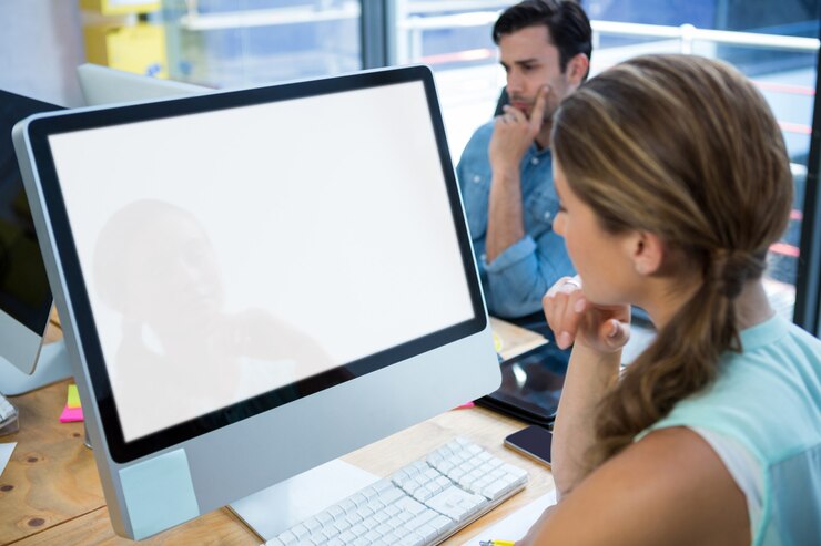 Foto bella mujer que trabaja en la pc de escritorio