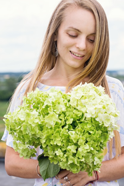 Bella mujer con un ramo de hortensias