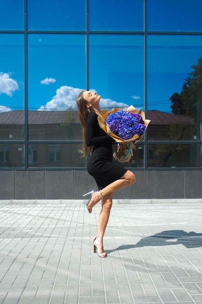 Bella mujer con un ramo de hortensias