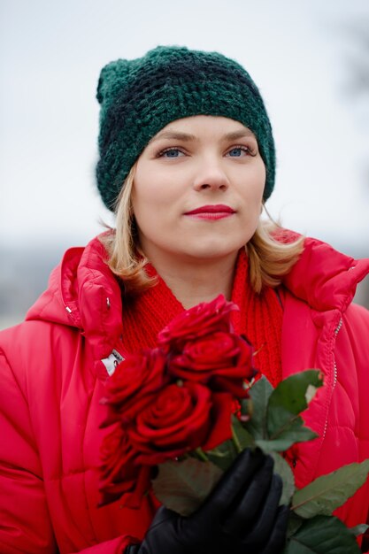 Bella mujer con un ramo de rosas rojas en sus manos