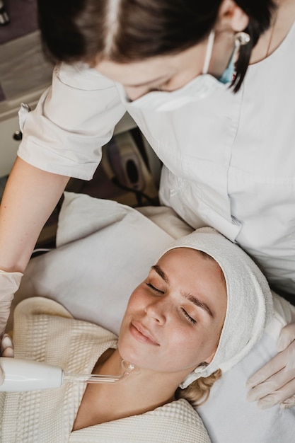 Foto bella mujer recibiendo un tratamiento facial en el spa